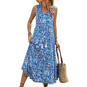 Detail of bohemian tiered dress with V-neckline, fringe tassels and artistic blue prints