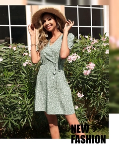 Detail of the green V-neck wrap dress with white floral prints and delicate puff sleeves