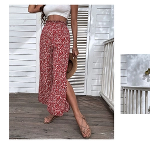 Detail of red floral high-waist wide-leg pants with elastic smocked waist and side slit