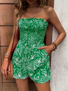 Detail of floral strapless romper featuring tropical leaf print and waist tie design