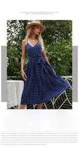 Close-up of the navy blue polka dot pleated midi dress featuring a V-neck and waist tie