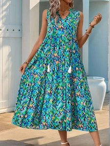 Detail of V-neckline with white tassel ties and colorful abstract bohemian print on dress