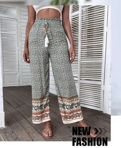 Détail d'un pantalon large bohème à imprimé fleuri avec cordon de serrage à pompons