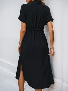 Detail view of the waist pleats and side slit on this black short sleeve midi dress