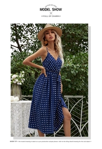 Detailed close-up of navy blue polka dot pleated midi dress with lace-up waist detail
