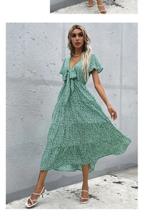 Detail of the green floral midi dress featuring a V-neckline and bow tie waist detail