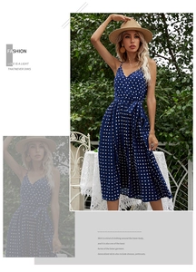 Detailed close-up of dark blue polka dot sundress featuring a tied waist and pleated hem