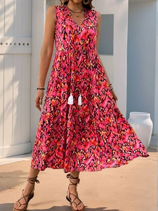 Detail of V-neck sleeveless maxi dress with bohemian print and white tassel ties