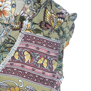 Détail de robe bohème verte à fleurs avec dentelle blanche et motif de papillon