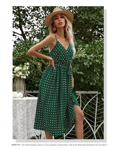 Detail of V-neck dark green polka dot dress with pleated skirt and waist tie tie