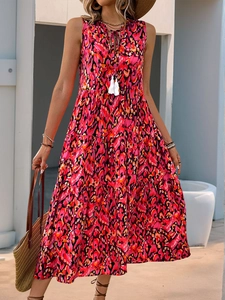 Detail of V-neckline with drawstring and white tassel balls on bohemian floral tiered dress