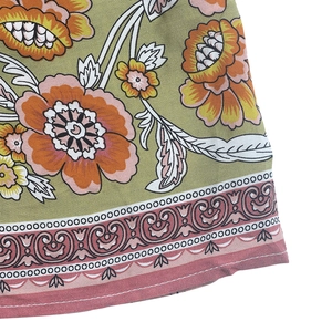 Détail du tissu à imprimé floral bohème avec base vert olive et fleurs orange