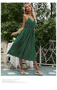 Detail of green polka dot midi dress showing V-neckline, spaghetti straps, and pleated skirt