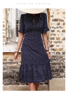 Détail de robe rétro à pois bleu marine avec nœud papillon au col et manches à volants