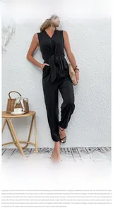 Detail view of black sleeveless V-neck romper with decorative waist tie on a female model