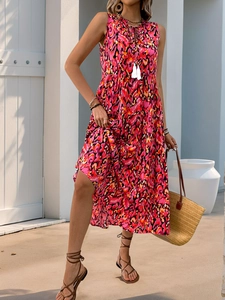 Detail of V-neckline with white tassels and vibrant abstract print on a maxi dress
