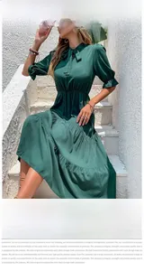 Detail of dark green midi dress with bow tie neckline and elegant ruffled sleeves