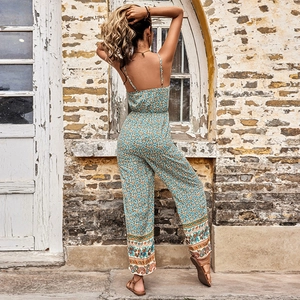 Bohemian floral jumpsuit with spaghetti straps and ethnic print on outdoor rustic background