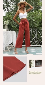 Détail des coutures soignées sur l'ourlet et la taille du pantalon large taille haute rouge
