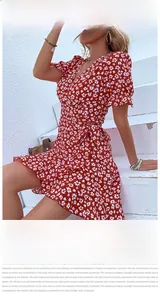 Detail view of red floral wrap dress with ruffle hem, V-neckline and waist tie