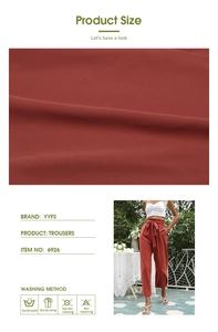 Détail du pantalon large taille haute rouge rouille avec nœud et texture du tissu
