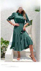Detail of elegant dark green tiered midi dress with tie neck and puff sleeves