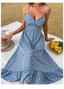 Detail of blue floral summer sundress with thin straps and ruffled chest on beach