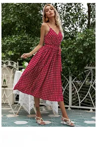 Detail of red polka dot midi dress showing the V-neckline, thin straps and pleated hemline