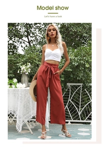 Shooting extérieur d'un pantalon large taille haute rouille avec une ceinture à nœud élégante