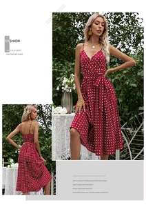 Detail of red polka dot V-neck midi dress featuring waist tie and pleated skirt design