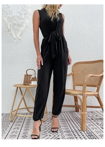 Detail of waist tie bow and elastic ankle cuffs on a black sleeveless jumpsuit