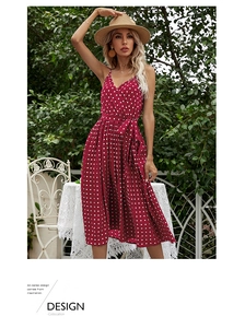 Detail of red polka dot dress featuring adjustable waist bow and pleated chiffon hemline