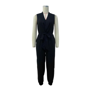 Detail of black sleeveless V-neck jumpsuit featuring a waist tie and cinched cuffs