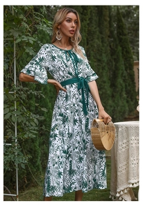 Detail of V-neck floral summer dress with tropical green leaf print and waist tie