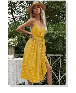 Detailed view of yellow polka dot dress showing spaghetti straps and tied waist detail