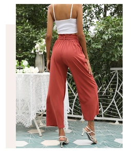 Détail de la vue arrière du pantalon large taille haute rouge rouille avec une ceinture élégante