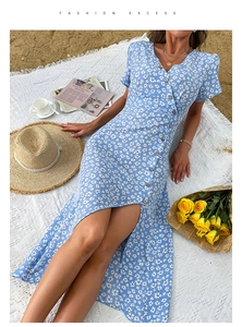 Détail de la robe d'été fleurie à col en V avec boutons et fente haute sur une plage