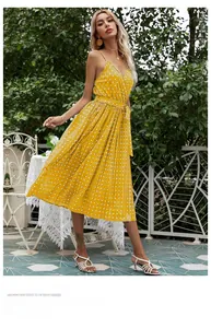 Detail of yellow polka dot midi dress showing pleated skirt texture and waist tie
