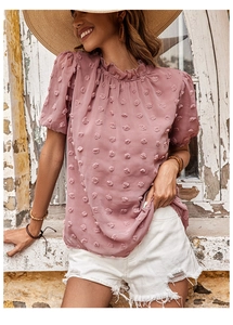 Dettaglio della camicia estiva in chiffon rosa con pois svizzeri e scollo a balze