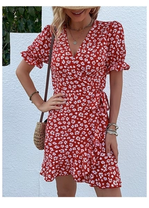 Detail of red floral wrap dress with ruffle hem and waist tie in natural light