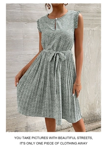 Detail of green floral sleeveless dress showing the pleated skirt and waist tie-belt