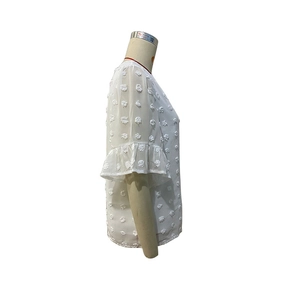Detailed side view of white chiffon top with ruffle sleeves and 3D textured pom-pom details