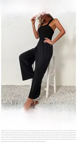 Detail eines schwarzen ärmellosen Jumpsuits mit weitem Bein, Plissee und elastischer Taille