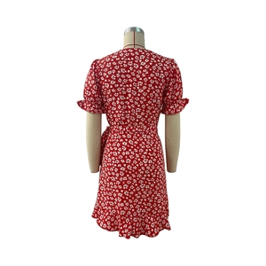 Detail view of the back of a red floral wrap dress with ruffle trims and waist tie