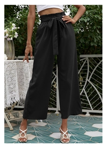 Détail du pantalon paperbag taille haute avec ceinture à nœud et tissu plissé noir