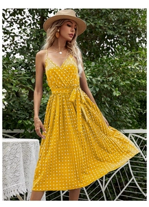 Detail view of yellow polka dot V-neck midi dress with adjustable waist tie and pleated skirt