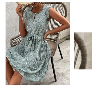 Detail of green floral summer dress showing ruffled sleeveless design and waist tie detail
