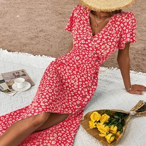 Détail d'une robe d'été à fleurs avec col en V, boutons et motif marguerites à la plage