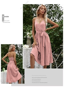 Detail of pink polka dot midi dress showing V-neckline and pleated hem in a garden setting