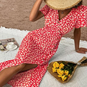Détail d'une robe rouge à fleurs avec col en V, imprimé marguerites et boutons pour les vacances